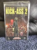 Photo of Kick-Ass 2 comic issue 3 in a protective bag and board on a carpeted floor.