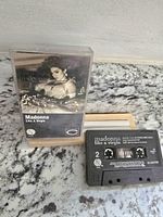 Photo showing Madonna Like A Virgin cassette tape with clear plastic case on granite surface.