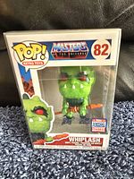 Photo showing new Whiplash Funko Pop figure in window display box with retro Masters of the Universe branding and San Diego Comic-Con 2017 exclusive sticker.