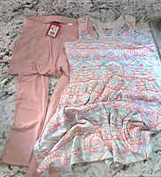 Light pink girls tights laid flat next to pastel Aztec patterned sleeveless dress