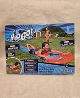 Front and top view of product box showing child sliding on water slide toy with branding and warnings visible