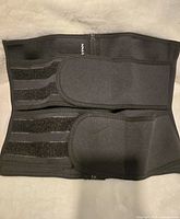 Top view of black stomach shaper girdle showing Velcro straps