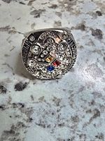 Front view of the NFL Pittsburgh Steelers championship replica ring showing face with multiple clear crystals and central colored stones.