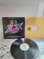 Full view of the Phantom of the Paradise soundtrack album cover, vinyl record, and original paper sleeve laid out on a surface.