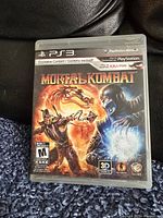Front cover art of Mortal Kombat PS3 game case showing main characters and game rating.