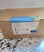 Box showing front label with description and illustration of the seed pod kit for hydroponic growing system including items inside.