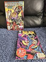 Two comic books placed on a carpeted floor showing their front covers: Supreme #1 and Raver 2nd Sensational Issue.