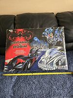 Original box artwork showing the Batman & Robin branding, logos, and Batmobile design on the top of the box.