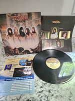 Full lot showing record, album cover, inner sleeve, and promotional insert on a granite counter surface.