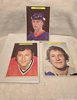 Front view of five O'Pee Chee NHL cards, including the signed 5x7 Mike Bossy card and three smaller cards showing player portraits.
