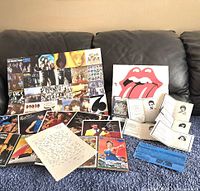 Overview photo showing all items laid out on a couch; large poster, multiple 8x10 photos, handwritten letter, postcard strip, passports, and ticket visible