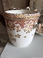 Close-up of chamber pot showing floral pattern and handle