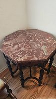 Octagonal marble top of the side table showing brown marble with beige and cream patterns.