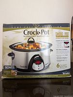 Front view of Rival Crock-Pot original box showing the 6-quart capacity, digital timer, Smart-Pot countdown, and bonus cookbook included.