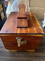 Closed wooden shoe polish box with metal latch and minor surface scratches.
