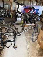 Side view of Diamondback Sorrento mountain bike with visible bike rack, bike lock, and pump in background.