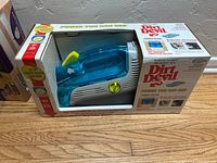 Dirt Devil Spot Scrubber handheld carpet cleaner in original box with blue and white housing, model information and branding on packaging.