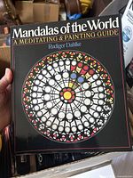 Front cover of 'Mandalas of the World' art book showing a colorful mandala design and author name Rudiger Dahlke.