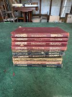 Stacked spines of 10 miniature vintage books showing gold embossed author names: Burroughs, Hale, Drummond, Foster, Lincoln, Montaigne, Bartlett, Thoreau