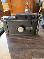 Back view of Polaroid Land Camera showing the textured black body and silver Polaroid logo plate.