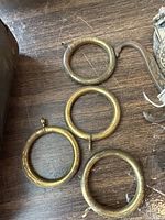 Four circular metal ring door knockers laid on wooden surface showing aged patina and wear.