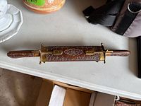 Full view of vintage Indian carving cutter and fork showing carved wood and brass design.