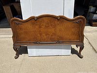 Front view of the antique wooden footboard showing curved top and decorative details