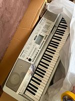 Yamaha DGX-300 keyboard in original box with packaging visible, showing full keyboard layout and silver body.