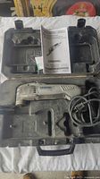 Dremel MM40 multi-tool inside molded black plastic carrying case with power cord and instruction manual