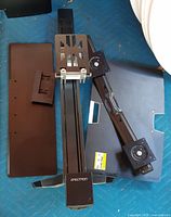 All components of Ergotron sit-stand mount laid out, showing rail, base, VESA pivots and accessory plate