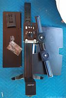 All major components laid out: column, crossbar with VESA plates, keyboard tray, work surface, hardware bag