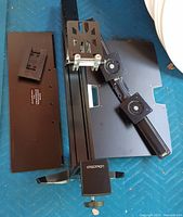 All main components laid out: column, cross-bar with VESA plates, keyboard tray, work surface panel