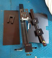 Full set of Ergotron components laid out: column, keyboard tray, monitor bar, small bracket