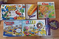 Overview of five boxed board games and Kerplunk tube