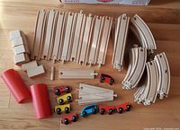 Overview of assorted wooden track pieces, ramps, splitters, elevators and toy vehicles