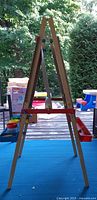 Side view of folded wooden easel showing A-frame structure
