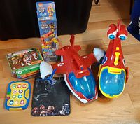 Lot overview showing two large vehicles, story reader, books, Tumbling Tower game and drawing board