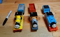 Three TrackMaster engines with corresponding cars and Sharpie for scale
