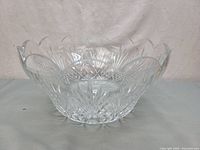 Crystal bowl on blank background showing side view of scalloped edge and cut patterns.