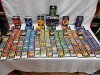 Wide view of multiple Lightseekers TCG booster and starter boxes with many individual cards from different factions laid out in rows.