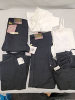 Photo showing multiple black leggings, black active shorts, and white tank tops all new with tags for kids urban active clothing.