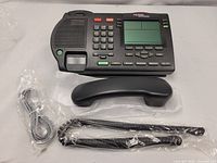 Top view showing the complete phone set including the handset, three antennas, and connecting cable still in plastic bags.