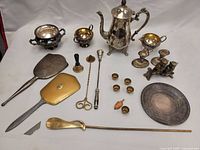 Overview of entire vintage precious metal lot including teapot, sugar bowl, creamer, candlesticks, trays, mirrors, goblets, and accessories