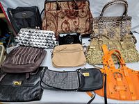 Lot of assorted purses and small handbags arranged on a flat surface