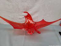 Front angle view of red translucent glass centerpiece with moose antler shape and clear glass base