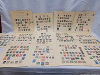 Wide view of ten album pages laid out, each with multiple postage stamps mounted.