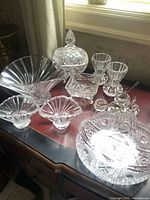 Full view of 12 crystal and cut glass pieces including bowls, vases, salt dishes, and a lidded dish.