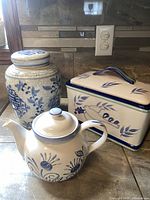 Photo showing the large ceramic lidded canister, teapot, and rectangular lidded dish in blue and white patterns on a kitchen counter.