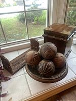 Image showing carved folding bookends, wooden decorative balls in a pedestal bowl, and hinged wooden box.