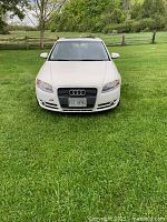 Front view of white Audi A4 showing grille, headlights, badge, license plate